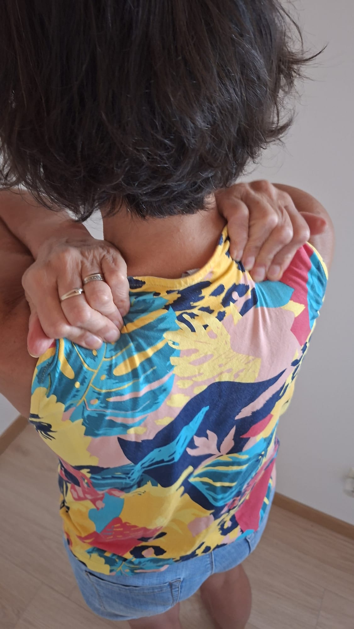 Femme de dos tee shirt comoré se massaeg uen épaule